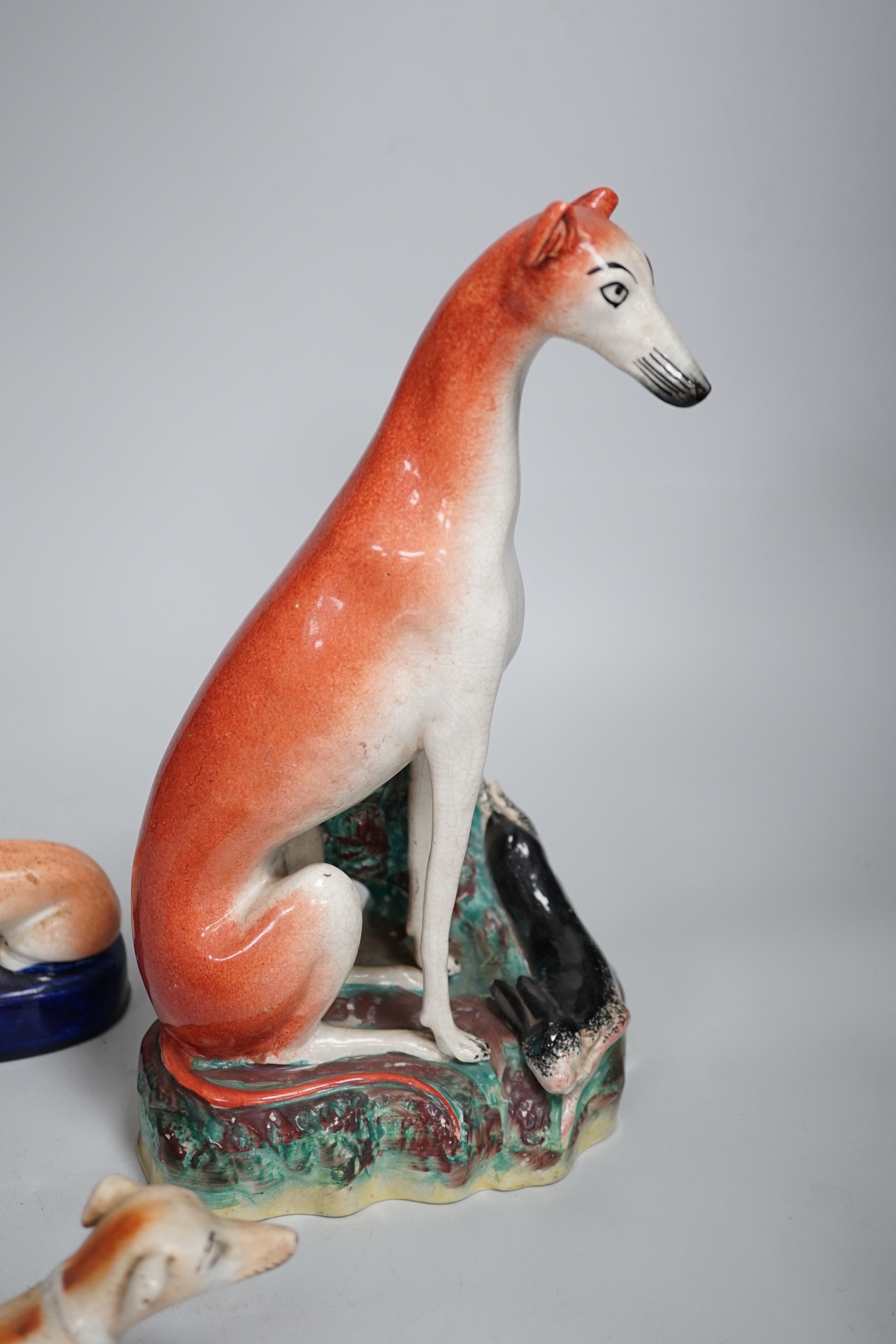 Four Staffordshire dogs including greyhounds and a spaniel, the largest 29cm high